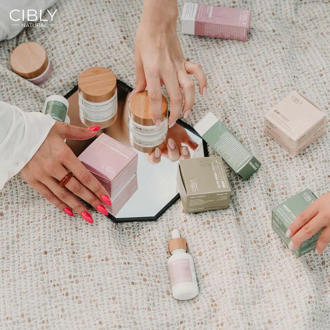 Продукти на Cibly Natural – околоочен крем, хидратиращ серум и нощен крем, поставени върху огледало, показващи натурална и качествена грижа за кожата.
