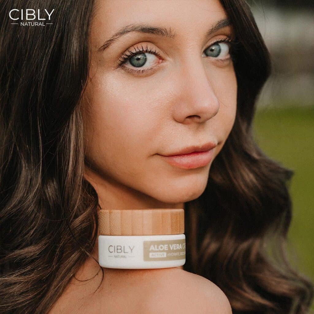Жена с естествена визия държи Крем с Алое Вера от Cibly, подчертавайки неговите хидратиращи и успокояващи свойства.