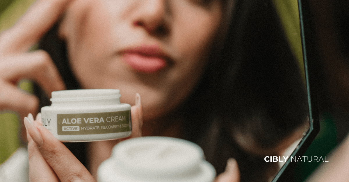 Жена прилага хидратиращ крем през пролетта сред цветя и свежест