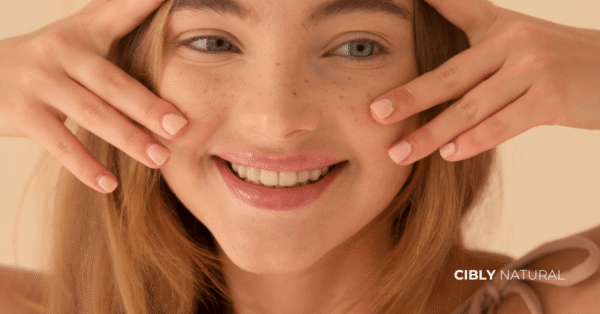 Жена в средата на 30-те докосва нежно лицето си като изучава фини линии и бръчки – натурална грижа за анти-ейдж