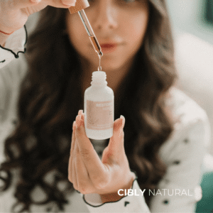 Жена нанася арганово масло на лицето - естествена грижа за кожата