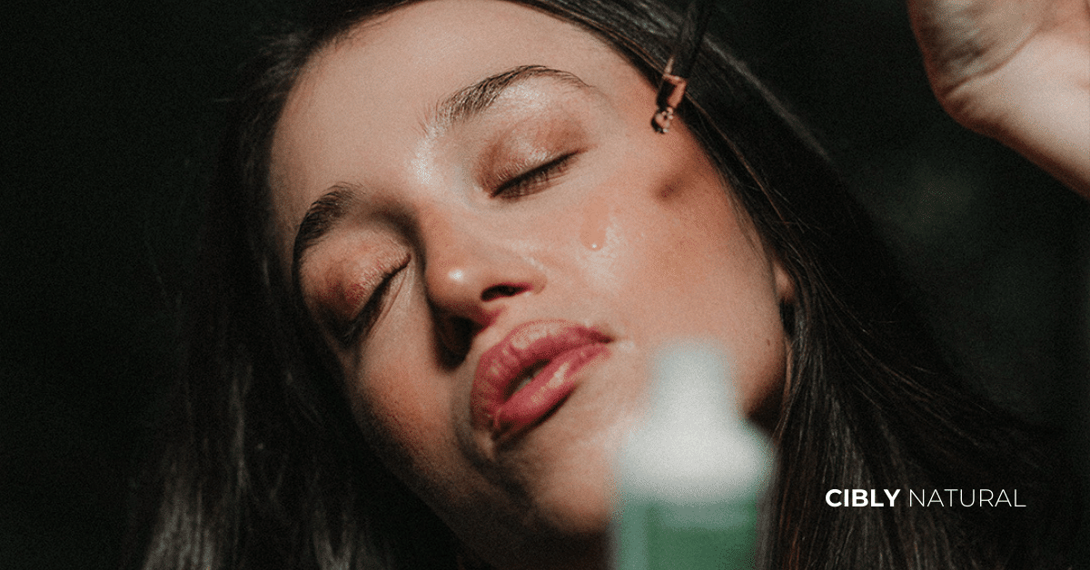 Жена с почистено лице нанася серум с пипетка вечер