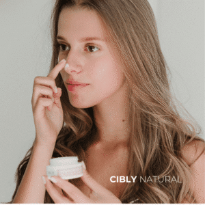 Жена с дълбоко хидратирана кожа на лицето нанася интензивен хидратиращ крем