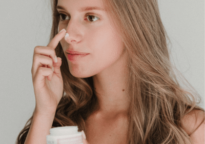 Жена с дълбоко хидратирана кожа на лицето нанася интензивен хидратиращ крем