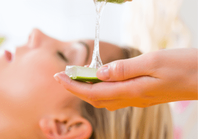 Прясно нарязан лист алое вера с прозрачен гел капва върху хидратирана кожа на лице